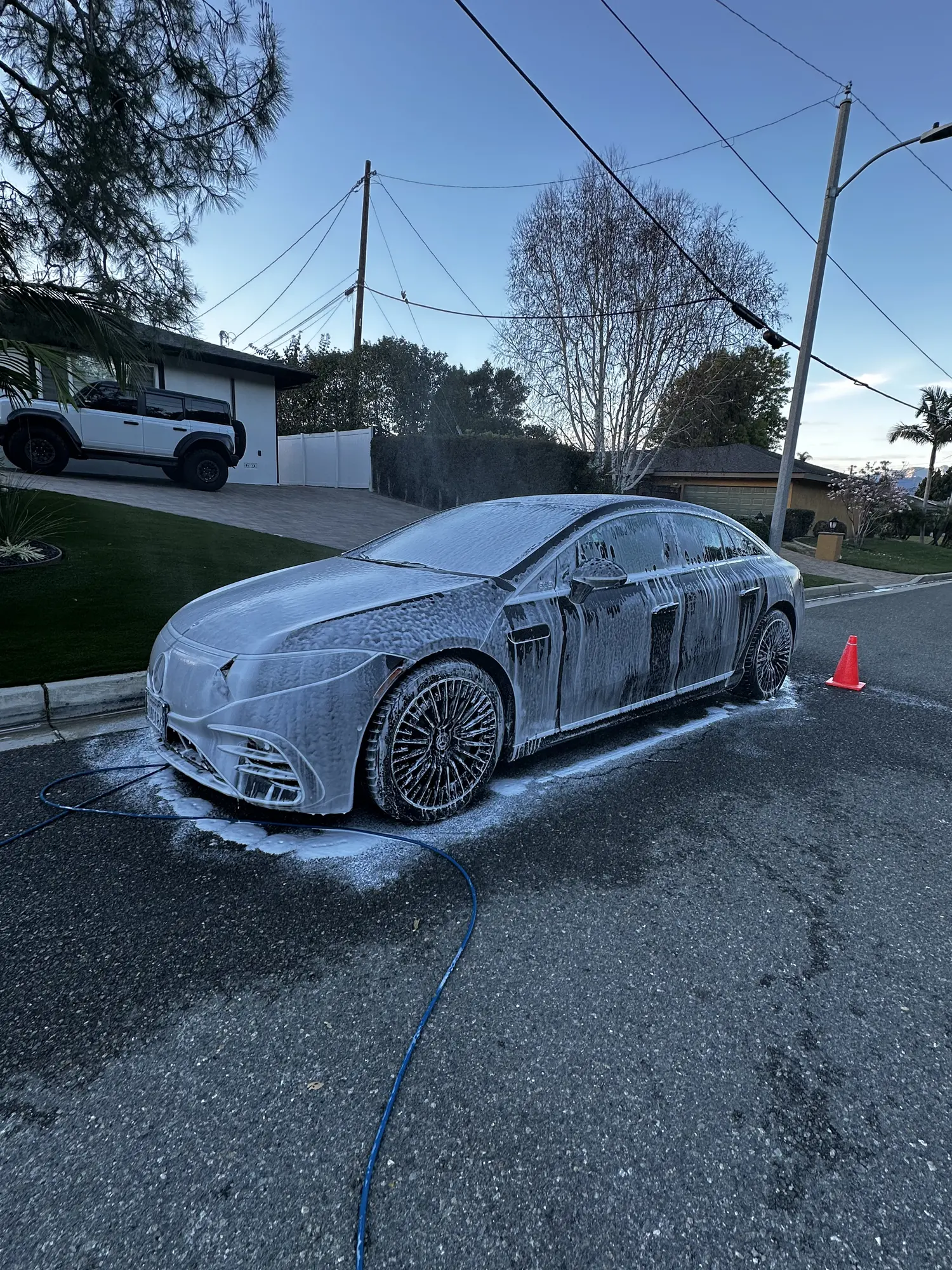 Luxury sedan covered in foam during a hand wash
